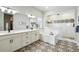 Elegant bathroom featuring double sinks, a soaking tub, and stylish tile flooring at 18212 W 95Th Pl, Arvada, CO 80007