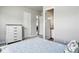 Comfortable bedroom with light walls showcasing a view to an ensuite bathroom and a stylish modern dresser at 18212 W 95Th Pl, Arvada, CO 80007