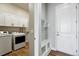 Well-organized laundry room equipped with modern washer and dryer, cabinet storage, and a convenient bench at 18212 W 95Th Pl, Arvada, CO 80007