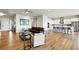 Spacious open-concept living room with hardwood floors, seamlessly flowing into a modern kitchen with a large center island at 18212 W 95Th Pl, Arvada, CO 80007