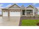 Charming single Gathering home featuring stone accents, a two car garage, and a well-manicured lawn at 1818 Sawtooth Mountain Dr, Berthoud, CO 80513