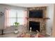 Cozy living room boasts stone fireplace, large window and hardwood floors at 8224 Washington St # 11, Denver, CO 80229