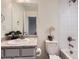 Well-lit bathroom featuring a modern vanity, toilet, and shower-tub with a tiled wall at 12920 Jasmine St # F, Thornton, CO 80602