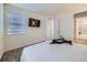 Bright bedroom featuring a mounted television and modern fixtures with ensuite bath at 12920 Jasmine St # F, Thornton, CO 80602
