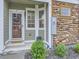 Inviting front entry with a storm door, olive green trim, and stone accents at 12920 Jasmine St # F, Thornton, CO 80602