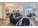 Open-concept living room featuring a modern black leather couch, area rug, and natural light at 12920 Jasmine St # F, Thornton, CO 80602