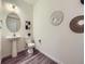 Stylish powder room featuring a pedestal sink, hardwood floors, decorative mirror, and modern decor at 12920 Jasmine St # F, Thornton, CO 80602