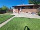 Spacious backyard with a concrete patio, brick house exterior, and well-maintained grass at 2902 Depew St, Wheat Ridge, CO 80214
