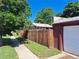 A backyard view with a wooden fence surrounding the property with garage in the background at 2902 Depew St, Wheat Ridge, CO 80214