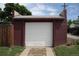A detached garage with a white garage door, brown pillars, and short driveway at 2902 Depew St, Wheat Ridge, CO 80214