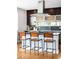 Kitchen island features modern stools, a sleek cooktop, and stylish pendant lighting, creating a chef's paradise at 5134 Quitman St, Denver, CO 80212