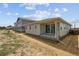 New construction home with a covered patio and view of backyard with neighboring houses at 45933 Wood Thrush Ave, Bennett, CO 80102