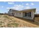 New construction home with a covered patio and view of backyard with neighboring houses at 45933 Wood Thrush Ave, Bennett, CO 80102