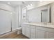 Bathroom features a glass shower, double sinks with white cabinets and a large mirror at 45933 Wood Thrush Ave, Bennett, CO 80102