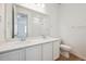 Bright bathroom featuring double sinks with white cabinets and a large mirror at 45933 Wood Thrush Ave, Bennett, CO 80102