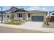 View of home with two-car garage, stone accents, neutral siding, and a small landscaped front yard at 45933 Wood Thrush Ave, Bennett, CO 80102