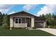 Charming single-story home with stone accents, a covered porch, and an attached two-car garage at 45933 Wood Thrush Ave, Bennett, CO 80102