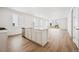 Open-concept kitchen with island, modern appliances, ample counter space, and light wood-look flooring at 45933 Wood Thrush Ave, Bennett, CO 80102