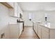 Modern kitchen with white cabinets, quartz countertops, stainless steel appliances, and light wood-look flooring at 45933 Wood Thrush Ave, Bennett, CO 80102