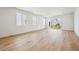 Bright living room with light wood-look flooring, white walls, and large sliding doors to the backyard at 45933 Wood Thrush Ave, Bennett, CO 80102