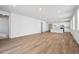 Spacious open-concept living space with light wood-look flooring, white walls, and recessed lighting at 45933 Wood Thrush Ave, Bennett, CO 80102