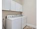 Functional laundry room with modern washer, dryer, and ample cabinet storage space at 1909 S Logan St, Denver, CO 80210