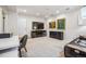 Finished basement area with white walls, carpeted floor, TV, a desk, and a comfortable black leather sofa at 479 Josephine St, Denver, CO 80206