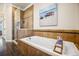 Bathroom featuring a white tub with tile surround and glass enclosed shower with tiled walls at 479 Josephine St, Denver, CO 80206