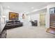 Spacious living room with white carpet, dark brown leather sofa, and staircase to the side at 479 Josephine St, Denver, CO 80206