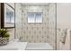 Modern bathroom with geometric tile, a soaking tub, and updated fixtures at 1227 Yost St, Aurora, CO 80011