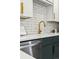 Close-up of a kitchen counter showing stainless appliances, custom two-tone cabinetry and bright tile backsplash at 1227 Yost St, Aurora, CO 80011