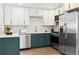 Well-equipped kitchen with stainless steel appliances, two-tone cabinets with gold handles, and light countertops at 1227 Yost St, Aurora, CO 80011