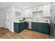 Stylish kitchen with two-toned cabinets, stainless appliances, tile backsplash and wood-look vinyl flooring at 1227 Yost St, Aurora, CO 80011