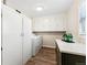 Bright laundry room featuring a modern countertop, sleek cabinets, and an efficient washer and dryer at 1227 Yost St, Aurora, CO 80011