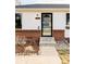 Front entry with brick and white siding, glass door, and landscaping at 4612 S Coors Ct, Morrison, CO 80465