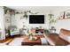 Living room with hardwood floors, leather sectional sofa, and abundant plants at 4612 S Coors Ct, Morrison, CO 80465