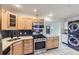 Kitchen with stainless appliances, light wood cabinets, granite countertops, and stacked washer dryer at 951 Tennyson St, Denver, CO 80204