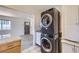 Convenient laundry area with stacked washer and dryer, plus natural light beaming from the interior at 951 Tennyson St, Denver, CO 80204