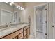 Bathroom with double vanity, granite countertop, framed mirror, and tiled walk-in shower at 692 Sage Forest Ln, Monument, CO 80132