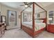 Bright bedroom features a four-poster bed, ceiling fan, and multiple windows at 692 Sage Forest Ln, Monument, CO 80132