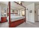 Bright bedroom features a four-poster bed, ceiling fan, and sliding door to the bathroom at 692 Sage Forest Ln, Monument, CO 80132