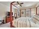 Bright bedroom features a four-poster bed, ceiling fan, and dresser with a mirror at 692 Sage Forest Ln, Monument, CO 80132