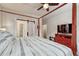 Bright bedroom features a four-poster bed, ceiling fan, and sliding door to the bathroom at 692 Sage Forest Ln, Monument, CO 80132