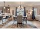 Dining area with chandelier lighting, kitchen breakfast bar, and large windows with modern decor at 692 Sage Forest Ln, Monument, CO 80132