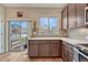 Modern kitchen showing granite counters, wood cabinets, stainless steel appliances, and sliding door access at 692 Sage Forest Ln, Monument, CO 80132