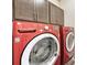 Laundry Room with a red washer and dryer and matching grey upper cabinets at 692 Sage Forest Ln, Monument, CO 80132