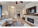 Living room features hardwood floors, ceiling fan, sectional sofa, and a fireplace at 692 Sage Forest Ln, Monument, CO 80132