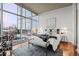 Modern bedroom with hardwood floors, a gray rug, and expansive city views at 1700 Bassett St # 1612, Denver, CO 80202