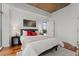 Bright bedroom featuring hardwood floors, a modern bed frame, and balcony access with city views at 1700 Bassett St # 1612, Denver, CO 80202