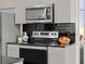 Close-up of kitchen appliances including stainless steel microwave and electric range with black countertops at 1700 Bassett St # 1612, Denver, CO 80202